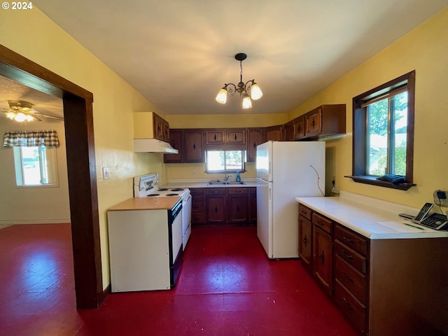 kitchen featuring pendant lighting, plenty of natural light, sink, and white appliances