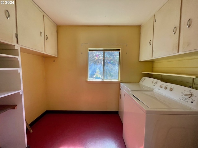 washroom featuring cabinets and washer and clothes dryer