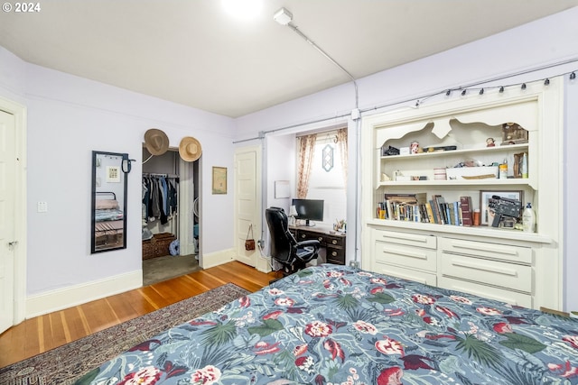 bedroom featuring a walk in closet, a closet, and light hardwood / wood-style floors