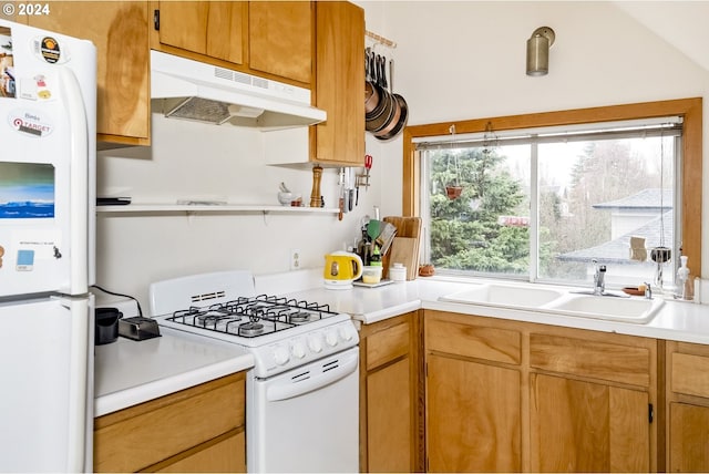 kitchen with white appliances, vaulted ceiling, and sink