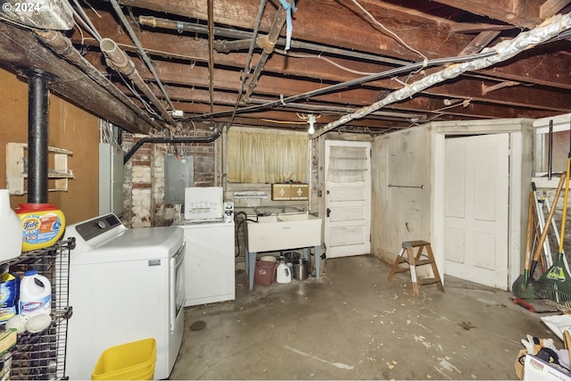 basement featuring sink, electric panel, and washing machine and clothes dryer