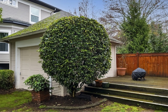 view of side of home featuring a garage and a wooden deck