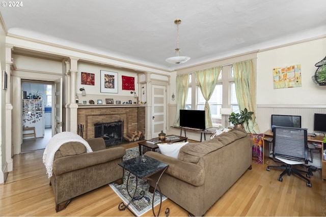 living room featuring light hardwood / wood-style floors, crown molding, and a fireplace