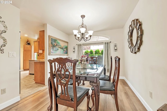 dining area featuring light wood-type flooring and a chandelier