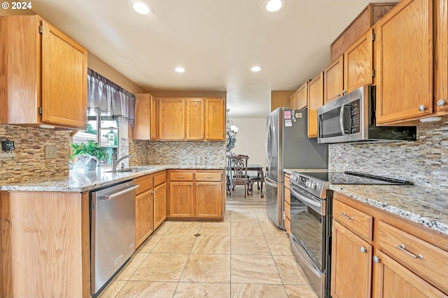 kitchen with sink, appliances with stainless steel finishes, decorative backsplash, light stone countertops, and light tile patterned floors