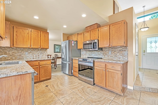 kitchen featuring tasteful backsplash, light stone countertops, sink, light tile patterned flooring, and stainless steel appliances