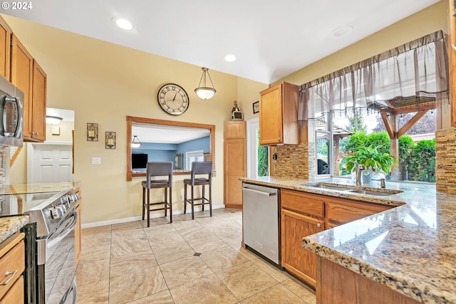 kitchen featuring appliances with stainless steel finishes, tasteful backsplash, sink, light stone counters, and light tile patterned flooring