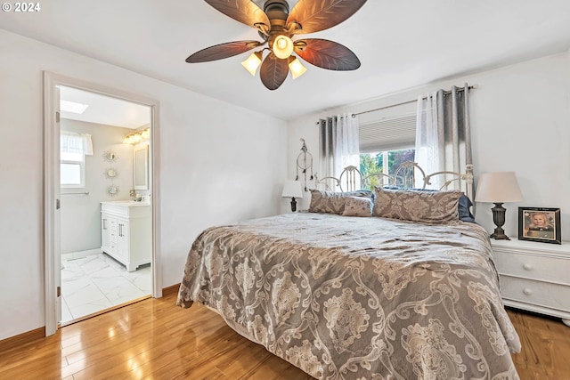 bedroom with sink, light hardwood / wood-style flooring, ceiling fan, and ensuite bath