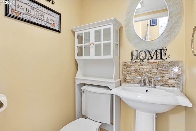 bathroom featuring tasteful backsplash and toilet