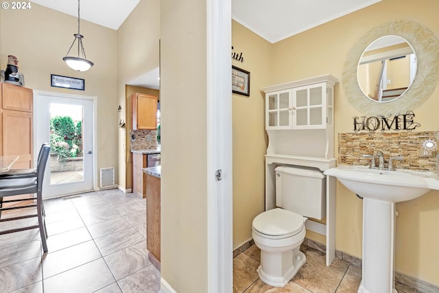 bathroom with sink, toilet, decorative backsplash, and tile patterned flooring