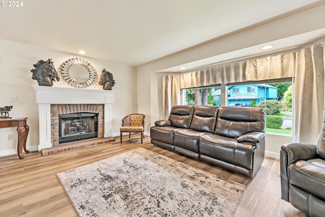 living room with a fireplace and light wood-type flooring