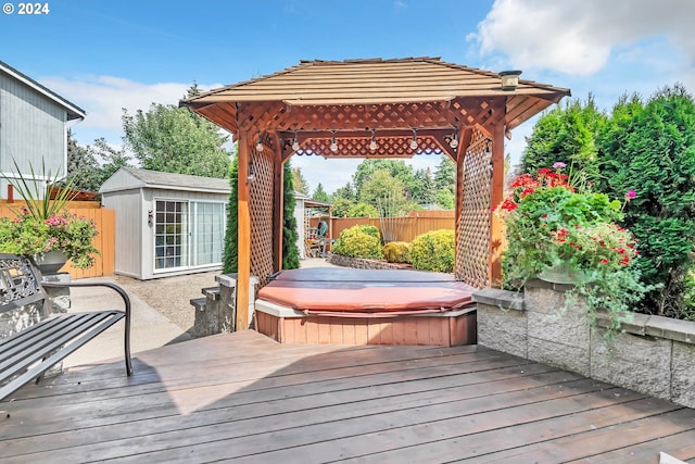 deck featuring a gazebo, a covered hot tub, and a shed