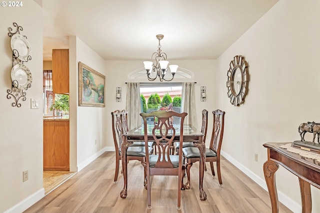 dining area with a notable chandelier and light hardwood / wood-style floors