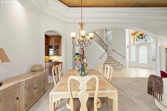 dining area featuring light carpet, a notable chandelier, and a wealth of natural light