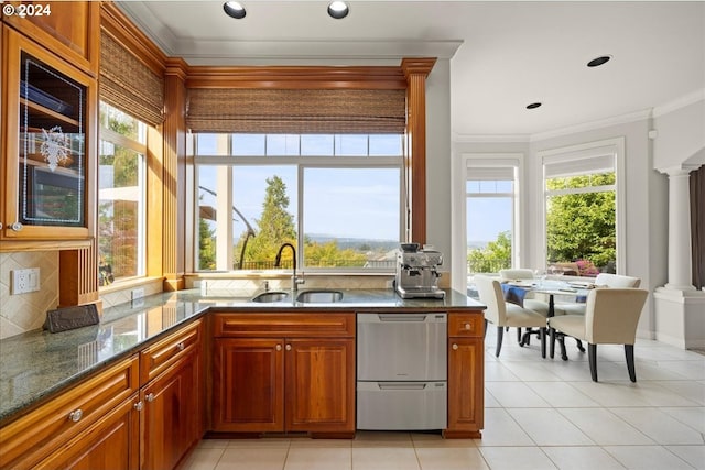 kitchen featuring dishwasher, sink, backsplash, crown molding, and ornate columns