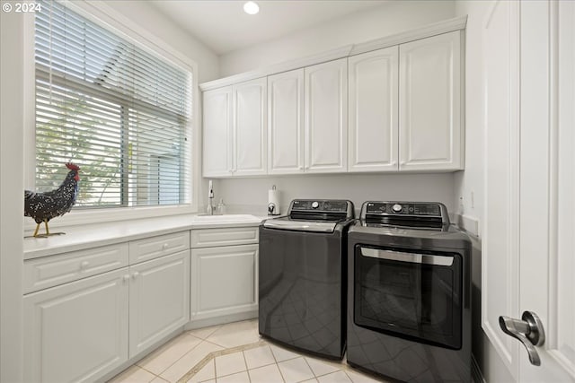 laundry area with cabinets, independent washer and dryer, light tile patterned flooring, and sink