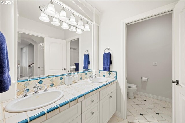 bathroom with backsplash, tile patterned flooring, vanity, and toilet