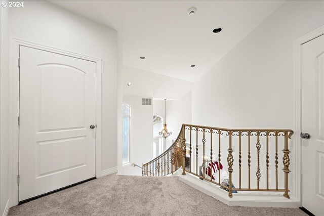 hallway featuring carpet and vaulted ceiling