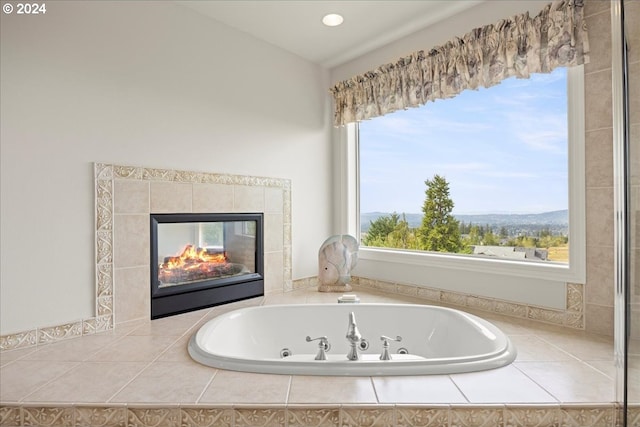 bathroom featuring a tiled fireplace and tiled tub