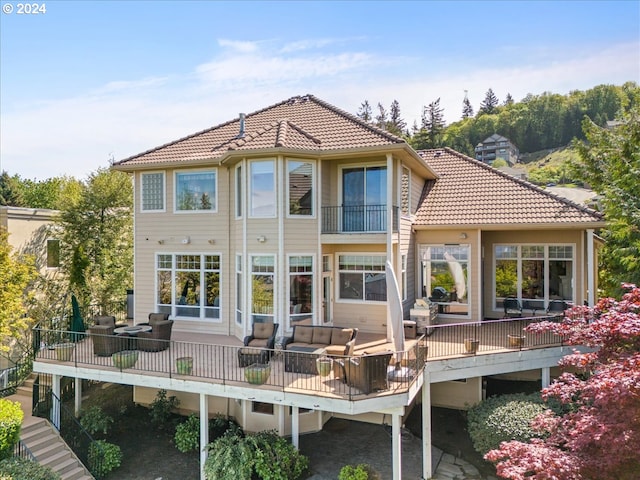 rear view of house featuring a balcony, an outdoor living space, and a deck