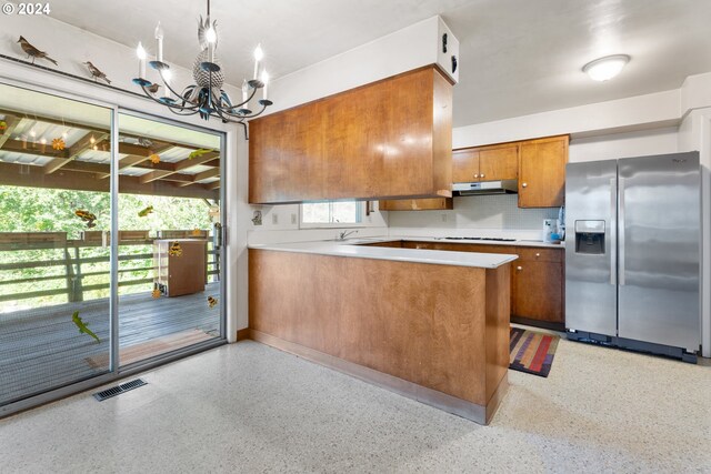 kitchen featuring an inviting chandelier, decorative light fixtures, a healthy amount of sunlight, and stainless steel appliances