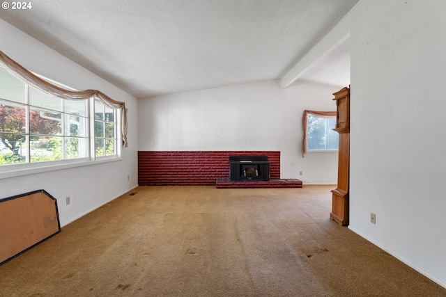 unfurnished living room featuring vaulted ceiling with beams, light carpet, a textured ceiling, and a wood stove