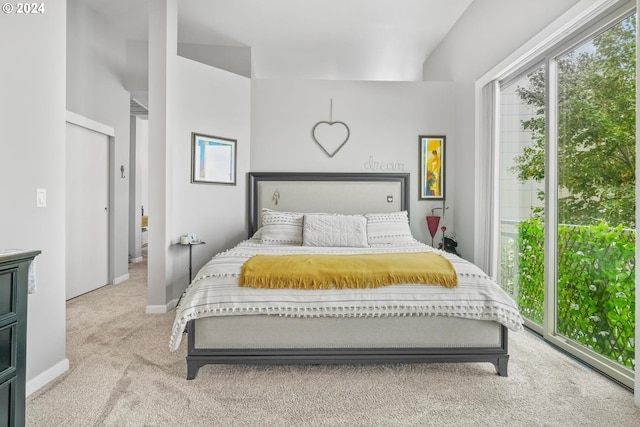 bedroom featuring access to exterior and light carpet