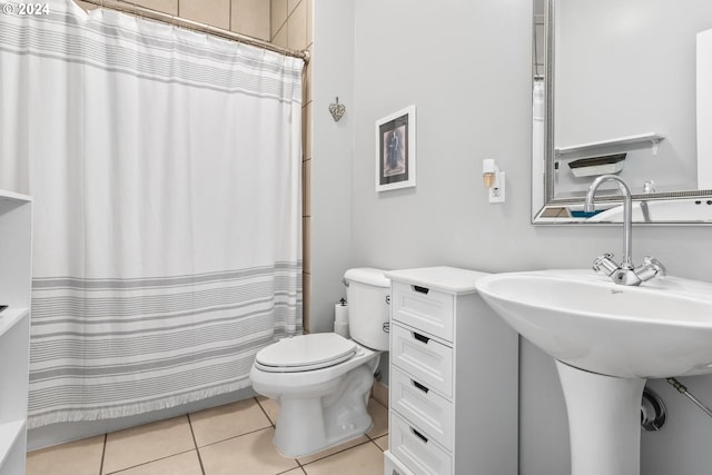 bathroom with toilet, tile patterned floors, walk in shower, and sink