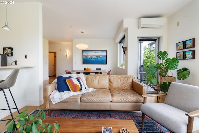 living room featuring wood-type flooring and an AC wall unit