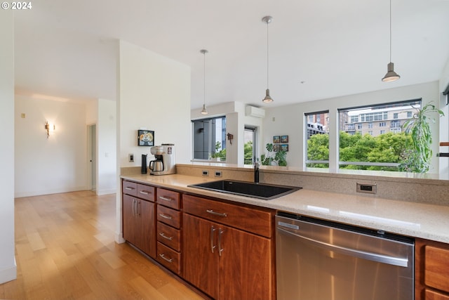 kitchen featuring dishwasher, light hardwood / wood-style floors, sink, and decorative light fixtures