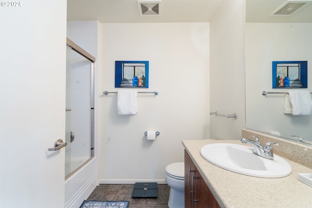 full bathroom featuring tile patterned flooring, vanity, toilet, and bath / shower combo with glass door