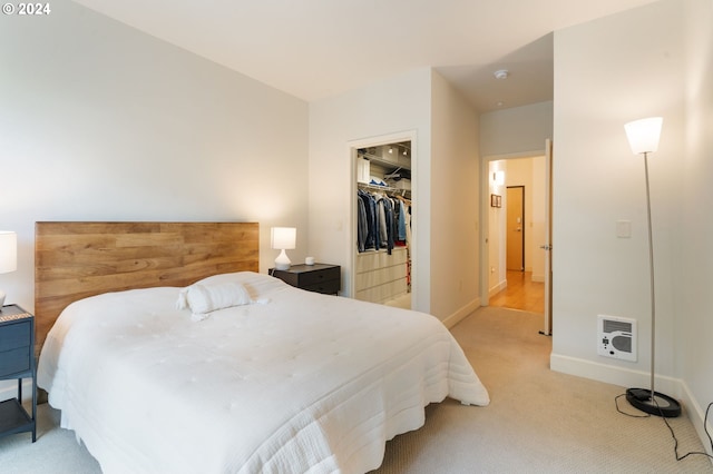 carpeted bedroom with a walk in closet, a closet, and heating unit