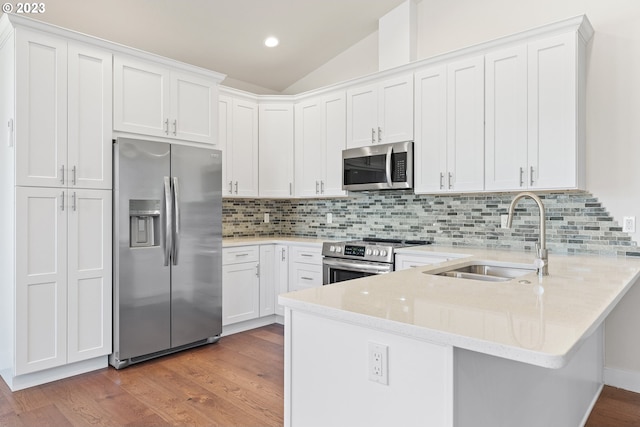 kitchen featuring sink, appliances with stainless steel finishes, light hardwood / wood-style flooring, white cabinetry, and lofted ceiling