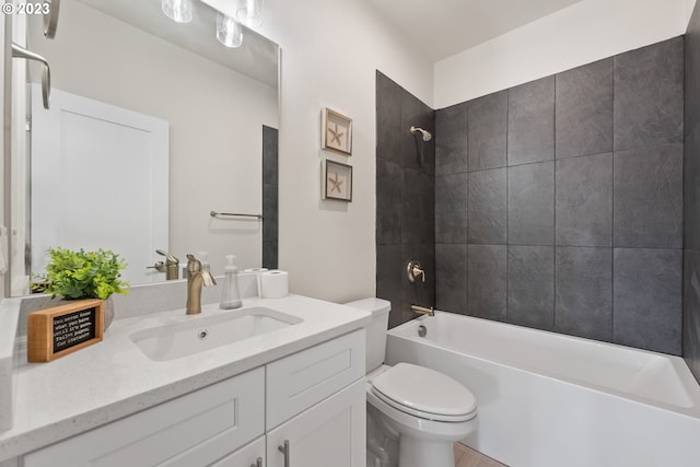 full bathroom featuring toilet, vanity with extensive cabinet space, and tiled shower / bath combo