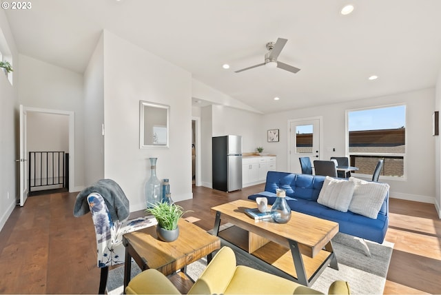 living room featuring ceiling fan, vaulted ceiling, and dark wood-type flooring