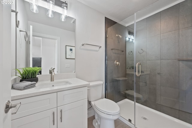 bathroom with walk in shower, large vanity, and toilet