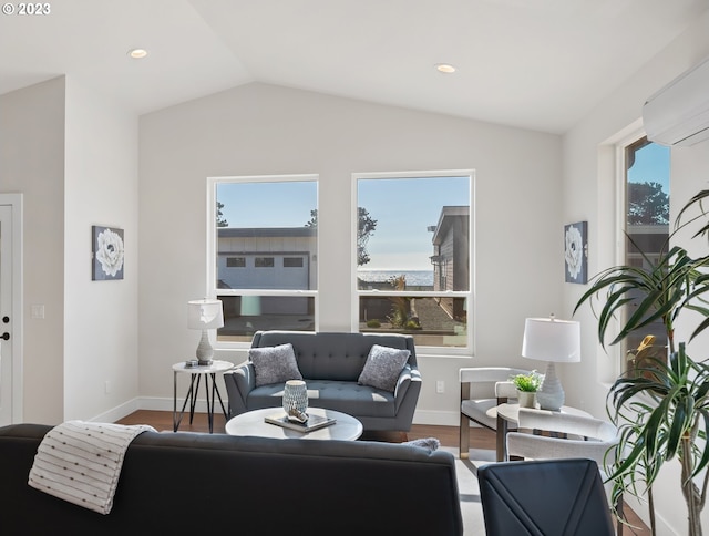 living room with an AC wall unit, vaulted ceiling, and hardwood / wood-style flooring