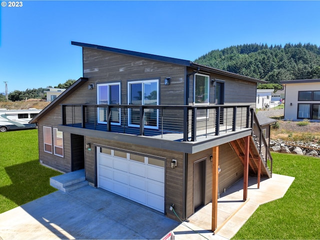 view of front of house with a balcony, a front yard, and a garage