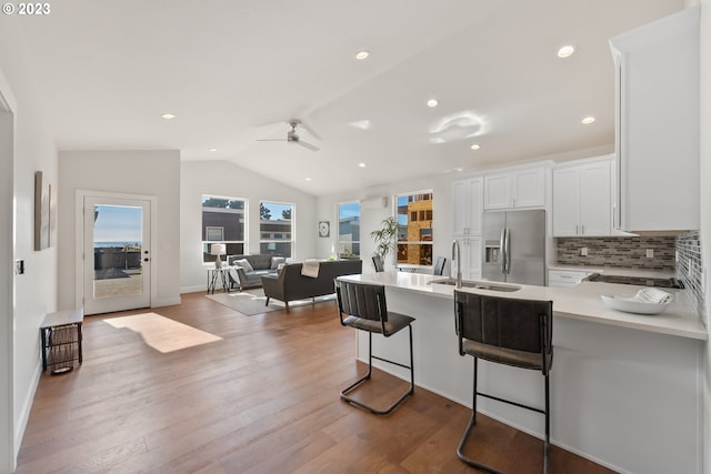 kitchen with white cabinetry, hardwood / wood-style floors, ceiling fan, lofted ceiling, and stainless steel refrigerator with ice dispenser