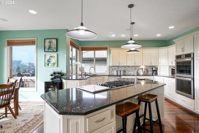 kitchen with decorative backsplash, a center island, dark hardwood / wood-style floors, and sink