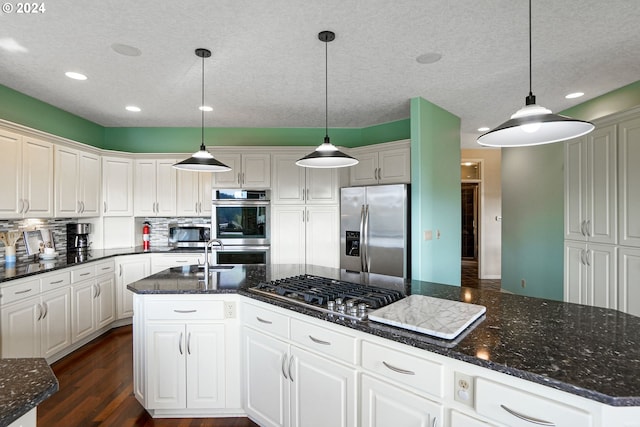 kitchen featuring pendant lighting, white cabinets, and stainless steel appliances