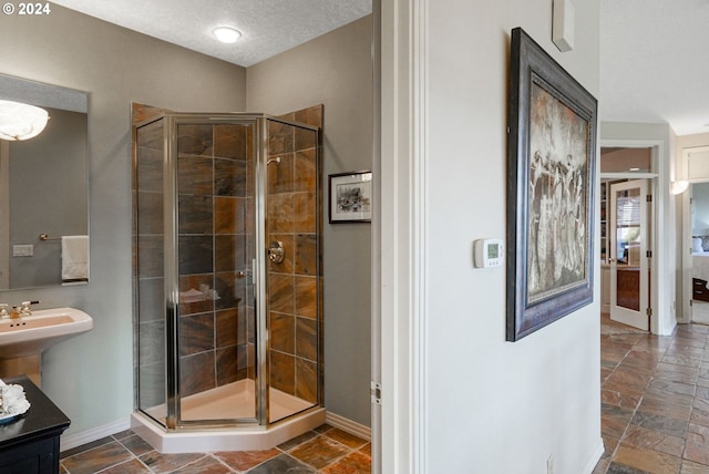 bathroom with a textured ceiling and a shower with shower door