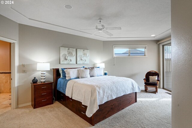 bedroom with a textured ceiling, light colored carpet, and ceiling fan