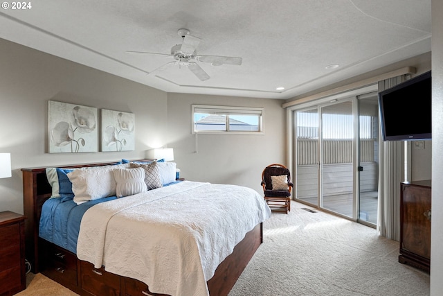 carpeted bedroom with ceiling fan, access to exterior, and a textured ceiling