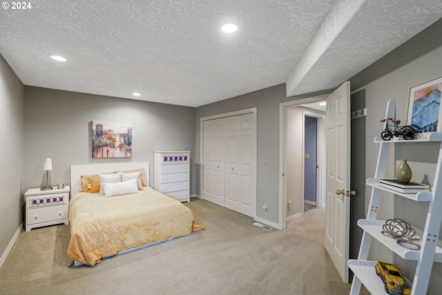 carpeted bedroom featuring a closet and a textured ceiling