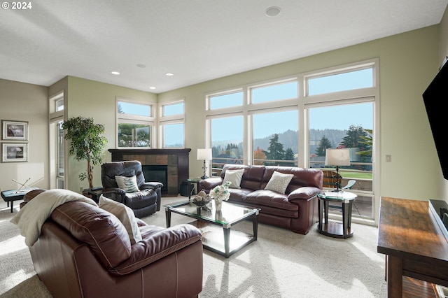 carpeted living room featuring a tiled fireplace