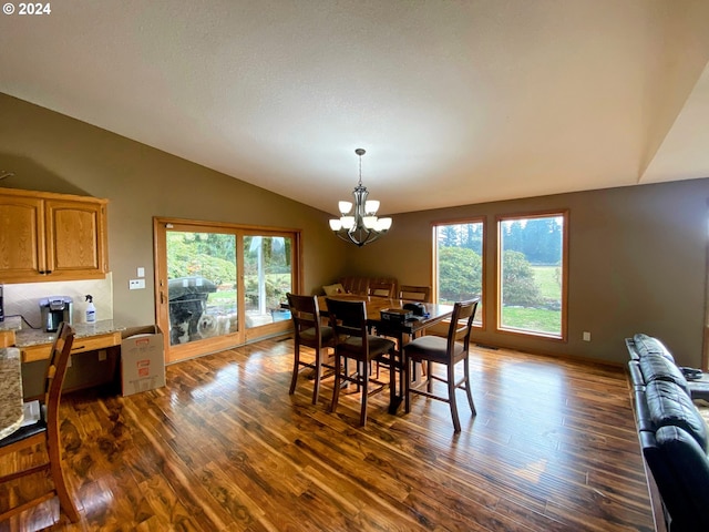 dining room with a wealth of natural light, vaulted ceiling, and dark hardwood / wood-style flooring