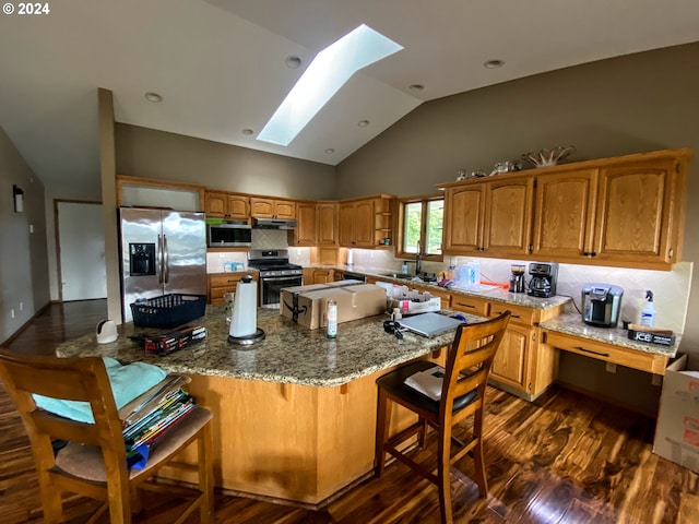 kitchen with decorative backsplash, dark wood-type flooring, stainless steel appliances, vaulted ceiling with skylight, and light stone counters