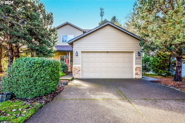 4505 NE Tide Ave, Lincoln City, OR 97367 - view of front of property featuring stone siding, asphalt driveway, and a garage