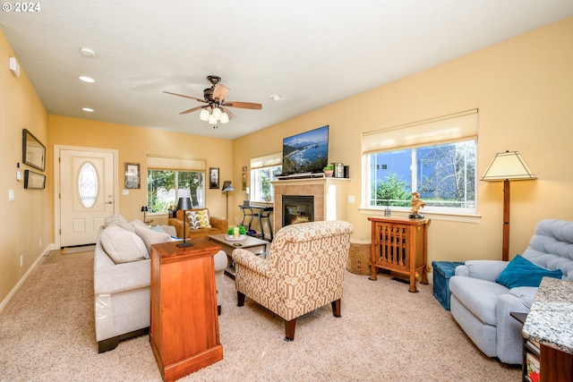 living room featuring a tile fireplace, plenty of natural light, and ceiling fan